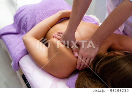 Top view of hands massaging female abdomen.Therapist applying pressure on belly. Woman receiving massage at spa salon 93193259