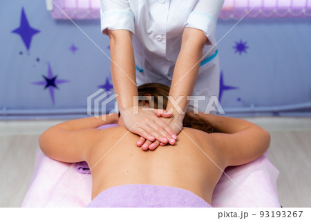 Top view of hands massaging female abdomen.Therapist applying pressure on belly. Woman receiving massage at spa salon 93193267