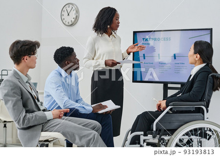 African businesswoman pointing at screen with charts and planning new strategy with her colleagues in teamwork African businesswoman pointing at screen with charts and planning new strategy with her colleagues in teamwork 93193813