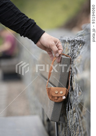 Someone lost a bag. A man 's hand takes a found lost thing - a small children 's women 's handbag . Abandoned or abandoned items, lost and found Someone lost a bag. A man 's hand takes a found lost thing - a small children 's women 's handbag . Abandoned or abandoned items, lost and found 93194060
