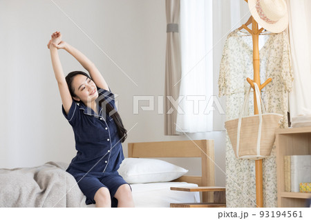 パジャマ姿で伸びをする女性 93194561