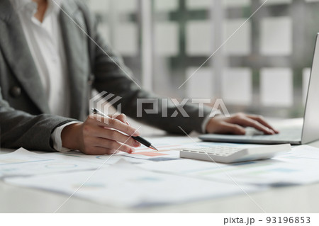 Business woman calculating the company's financial results and budget Business woman calculating the company's financial results and budget 93196853