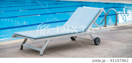 Picture of a sun bed chair on the edge of a hotel or resort swimming pool 93197862