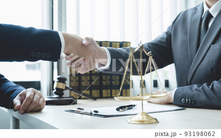 Handshake after Lawyer  providing legal consult business dispute service to the man at the office with justice scale and gavel hammer 93198062