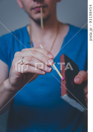 Close-up of adult man lights up with matches and smoking medical marijuana joint 93198454