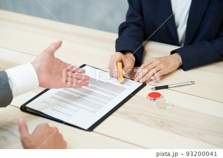 書類にハンコを押す女性 93200041