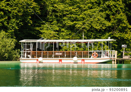 Excursion ship stands near the pier against green forest. Touristic attraction in natural park reserve on Plitvice lakes 93200891