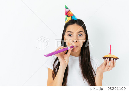 Young woman celebrating surprised blows in kazoo Young woman celebrating surprised blows in kazoo 93201109