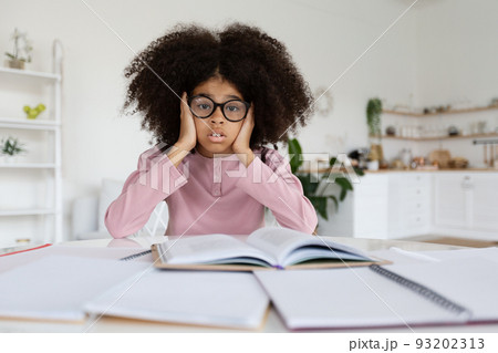 Overwhelmed african american school girl doing homework 93202313