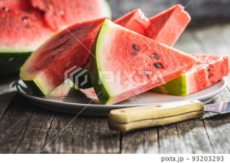 Slices of red watermelon on plate on wooden table. Slices of red watermelon on plate on wooden table. 93203293