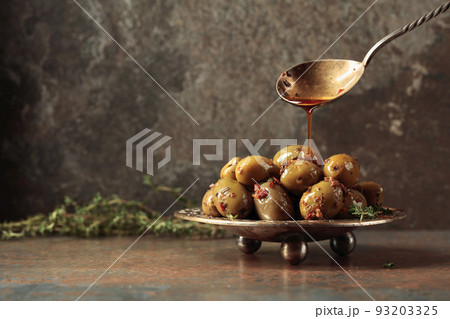 Spicy green olives are poured with olive oil with spices. Spicy green olives are poured with olive oil with spices. 93203325