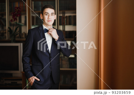 Grooms morning preparation. Handsome man getting dressed and preparing for the wedding Grooms morning preparation. Handsome man getting dressed and preparing for the wedding 93203659