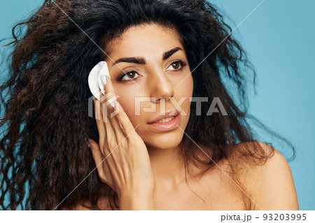 Pensive Latin female remove makeup with cotton pads, use lotion toner, look aside posing isolated over blue background. Cosmetic product ad Natural beauty Skincare concept Anti wrinkle procedure Pensive Latin female remove makeup with cotton pads, use lotion toner, look aside posing isolated over blue background. Cosmetic product ad Natural beauty Skincare concept Anti wrinkle procedure 93203995