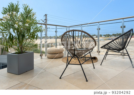 A cozy place to relax and unwind. Round wicker chairs, stylish interior items 93204292