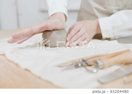 woman ceramist in the workshop makes mugs out of clay. small business or hobby is the creation of ceramic products 93204480