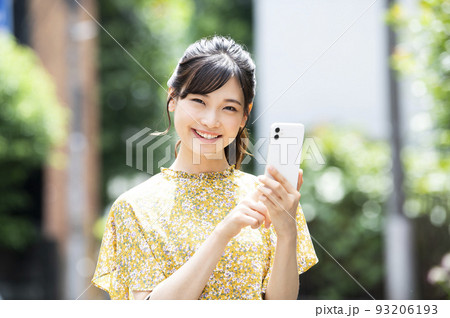 スマホ　若い女性　検索　調べる　笑顔　カメラ目線 93206193
