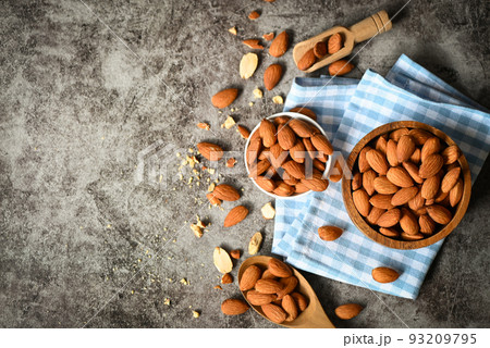 Almonds nuts on wooden bowl and dark background, Delicious sweet almonds on the table, roasted almond nut for healthy food and snack Almonds nuts on wooden bowl and dark background, Delicious sweet almonds on the table, roasted almond nut for healthy food and snack 93209795