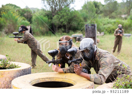 Couple of paintball players playing paintboll outdoors 93211189