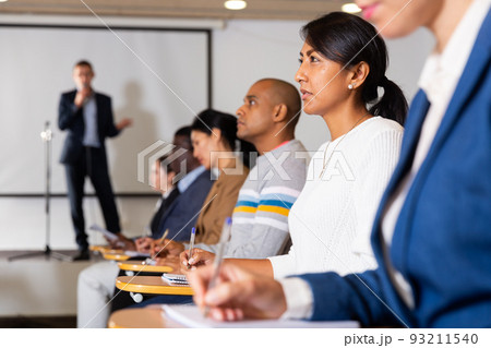 Hispanic female entrepreneur sitting in conference hall at business event 93211540