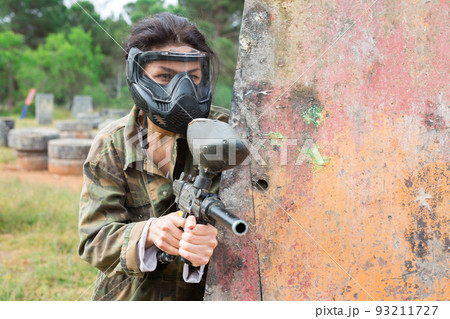 Group of people in full gear playing paintball on shooting range outdoor 93211727