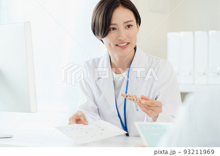 薬を渡す白衣姿の女性 93211969