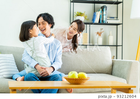 リビングでくつろぐ若い家族 リビングでくつろぐ若い家族 93212604