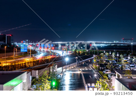 羽田空港を飛び立つ飛行機の光跡と夜の道路を走る車と多摩川スカイブリッジの夜景｜東京都羽田空港周辺 93213450