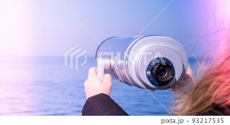 Tourist looking through coin operated binoculars. Discover new places Binocular telescope on the observation deck for tourism. Sea background. Sopot on the pier Binoculars watching at horizon at ship Tourist looking through coin operated binoculars. Discover new places Binocular telescope on the observation deck for tourism. Sea background. Sopot on the pier Binoculars watching at horizon at ship 93217535