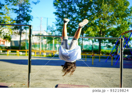 公園の鉄棒で逆上がりの練習をする女の子。小学3年生の夏休み。の写真素材 [93219824] - PIXTA