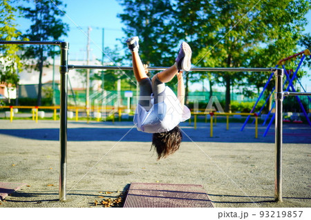 公園の鉄棒で逆上がりの練習をしている女の子の写真素材 [93219857] - PIXTA