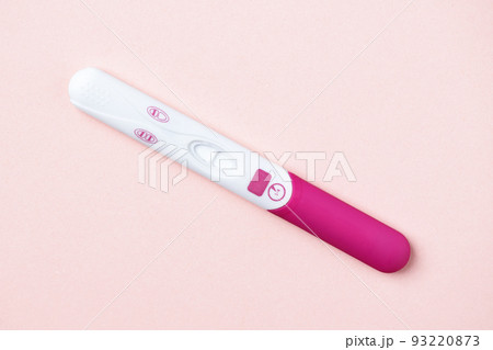 Pink positive pregnancy test on pink background. Positive result of pregnancy test. Pink positive pregnancy test on pink background. Positive result of pregnancy test. 93220873