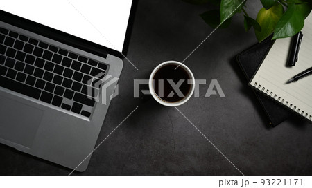 Top view laptop, cup go coffee, and notepad on black wooden table Top view laptop, cup go coffee, and notepad on black wooden table 93221171