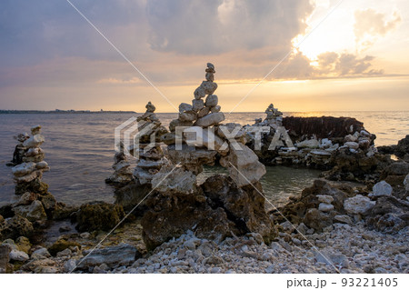 The stones are laid out in a column. Weathered marine limestone. Bizarre shape of stones on the seashore The stones are laid out in a column. Weathered marine limestone. Bizarre shape of stones on the seashore 93221405