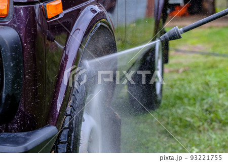 Car wash in the afternoon outdoors with a high-pressure apparatus. Car wash in the afternoon outdoors with a high-pressure apparatus. 93221755