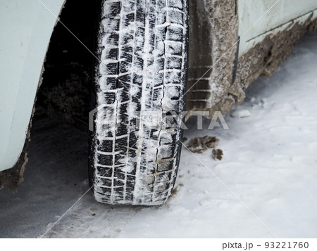 Close-up of a winter car tire tread with snow and ice. Close-up of a winter car tire tread with snow and ice. 93221760