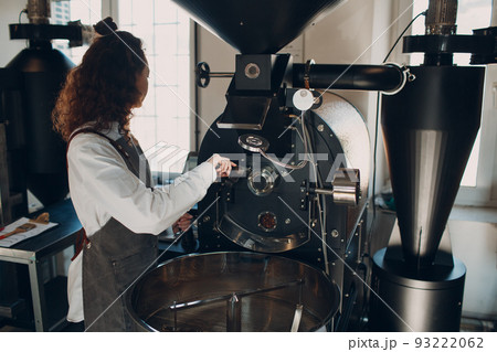Coffee roaster machine and barista with tryer at coffee roasting process. Coffee roaster machine and barista with tryer at coffee roasting process. 93222062