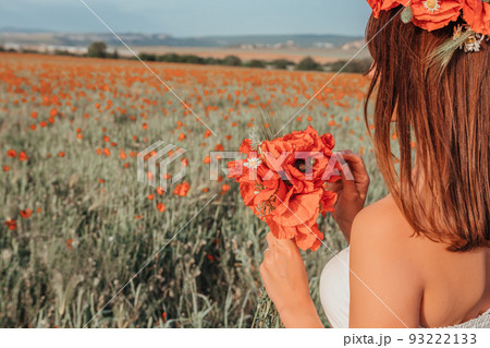 Bride in a white dress holding a bouquet of poppy flowers, warm sunset time on the background of the red poppy field. Copy space. The concept of calmness, silence and unity with nature. Bride in a white dress holding a bouquet of poppy flowers, warm sunset time on the background of the red poppy field. Copy space. The concept of calmness, silence and unity with nature. 93222133