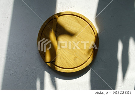Round wooden cutting board on white table. Copy space for text. Food and menu background.. Mockup 93222835