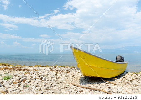 Yellow motor boat on shore of wonderful Skadar lake on the background of mountains. Amazing giant Skadar Lake is a famous bird nature reserve in Balkans located in Albania and Montenegro. Yellow motor boat on shore of wonderful Skadar lake on the background of mountains. Amazing giant Skadar Lake is a famous bird nature reserve in Balkans located in Albania and Montenegro. 93225229