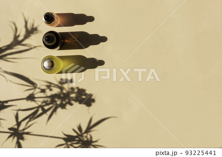 glass bottle with CBD oil, THC tincture on a pastel background with cannabis leaves shadows. minimalism. Cosmetics 93225441