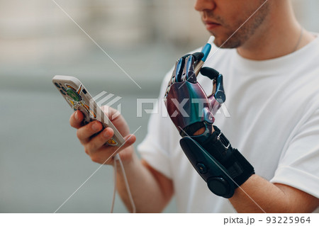 Young disabled man smoke electronic cigarette with artificial prosthetic hand in casual clothes 93225964