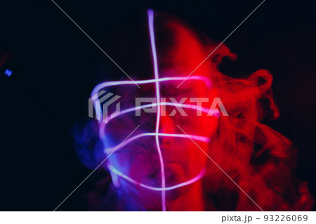 Portrait of man with neon glow tube lines on his face in dark. Concept cyberpunk and virtual reality 93226069