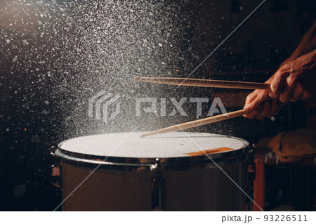 Close up drum sticks drumming hit beat rhythm on drum surface with splash water drops Close up drum sticks drumming hit beat rhythm on drum surface with splash water drops 93226511
