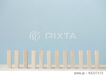 Domino block isolated pieces standing in a row on blue background. 93227172