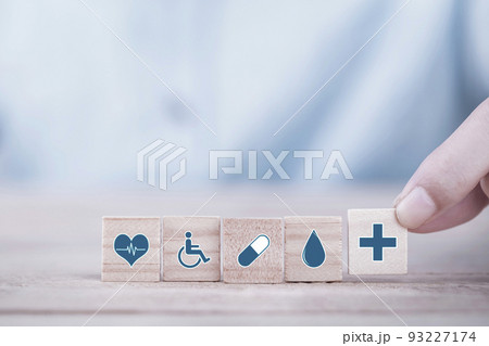 Hand chooses a emoticon icons healthcare medical symbol on wooden block , Healthcare and medical Insurance concept 93227174