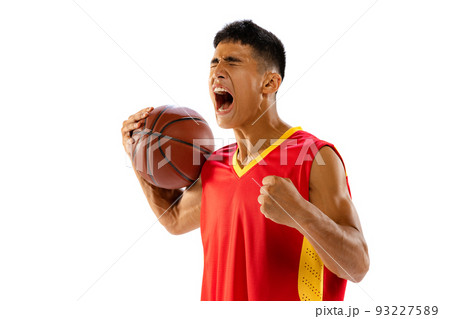 Portrait of young man, basketball player with ball in red uniform screaming, growing team spirit isolated over white studio background 93227589