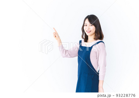 エプロンを着ておすすめを示す若い女性 93228776