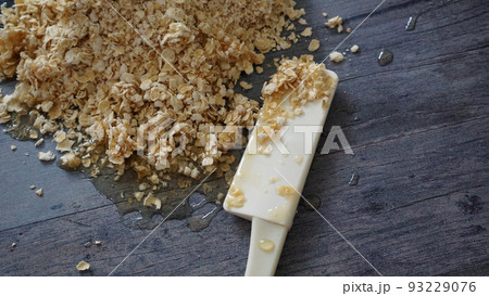 蜂蜜がかかったオートミールとクッキングツールのヘラ 93229076