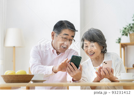 スマートフォンを操作する笑顔のシニア夫婦 スマートフォンを操作する笑顔のシニア夫婦 93231412