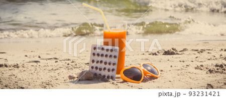 Vintage photo, Medical pills, carrot juice and sunglasses on sand at beach, vitamin A and beautiful Vintage photo, Medical pills, carrot juice and sunglasses on sand at beach, vitamin A and beautiful 93231421